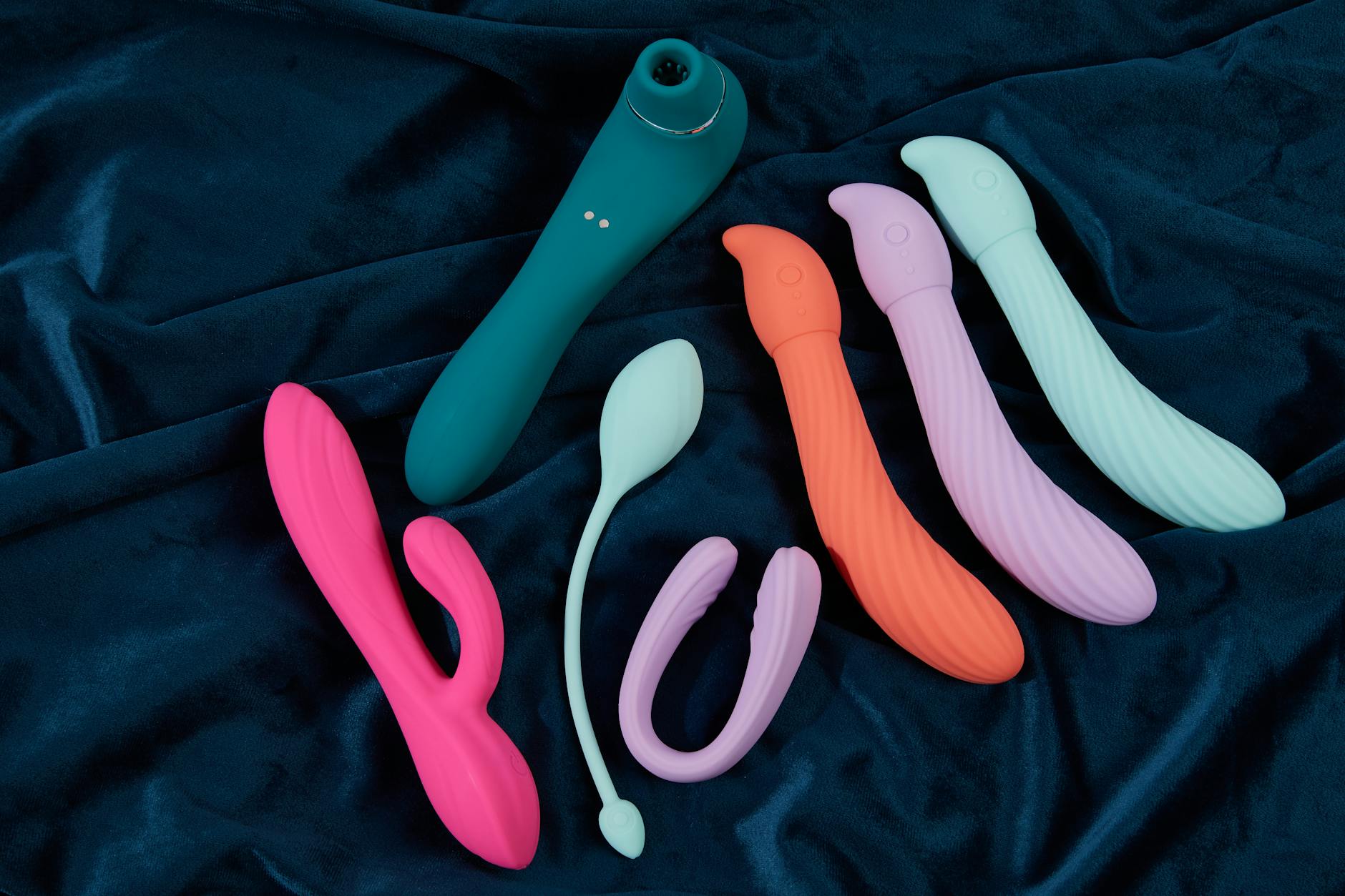 A young couple standing together indoors, holding modern pleasure device