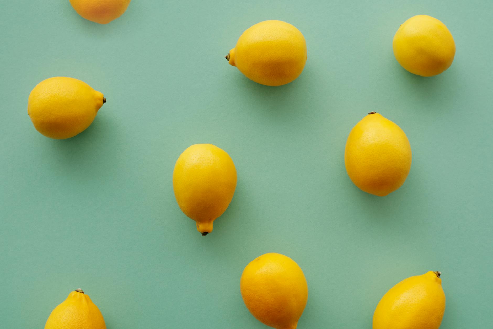 Bright yellow lemons arranged on a pastel green background, representing the gentle, expansive nature of broad clitoral stimulation