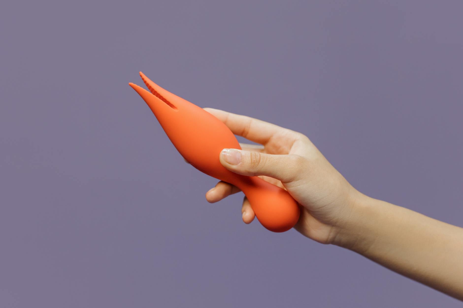 A hand holding a lemon vibrator against a minimalistic backdrop, showcasing modern sensuality and pleasure.