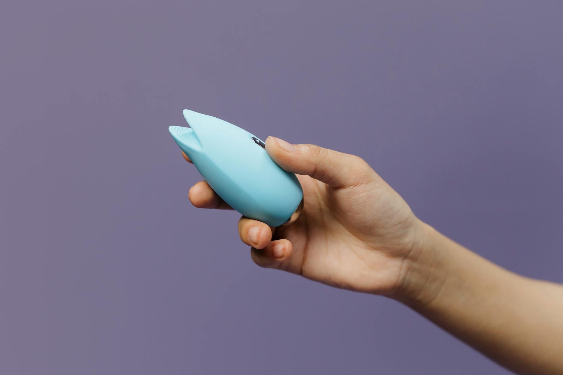 Three colorful vibrators arranged on white fabric, highlighting smooth texture and design