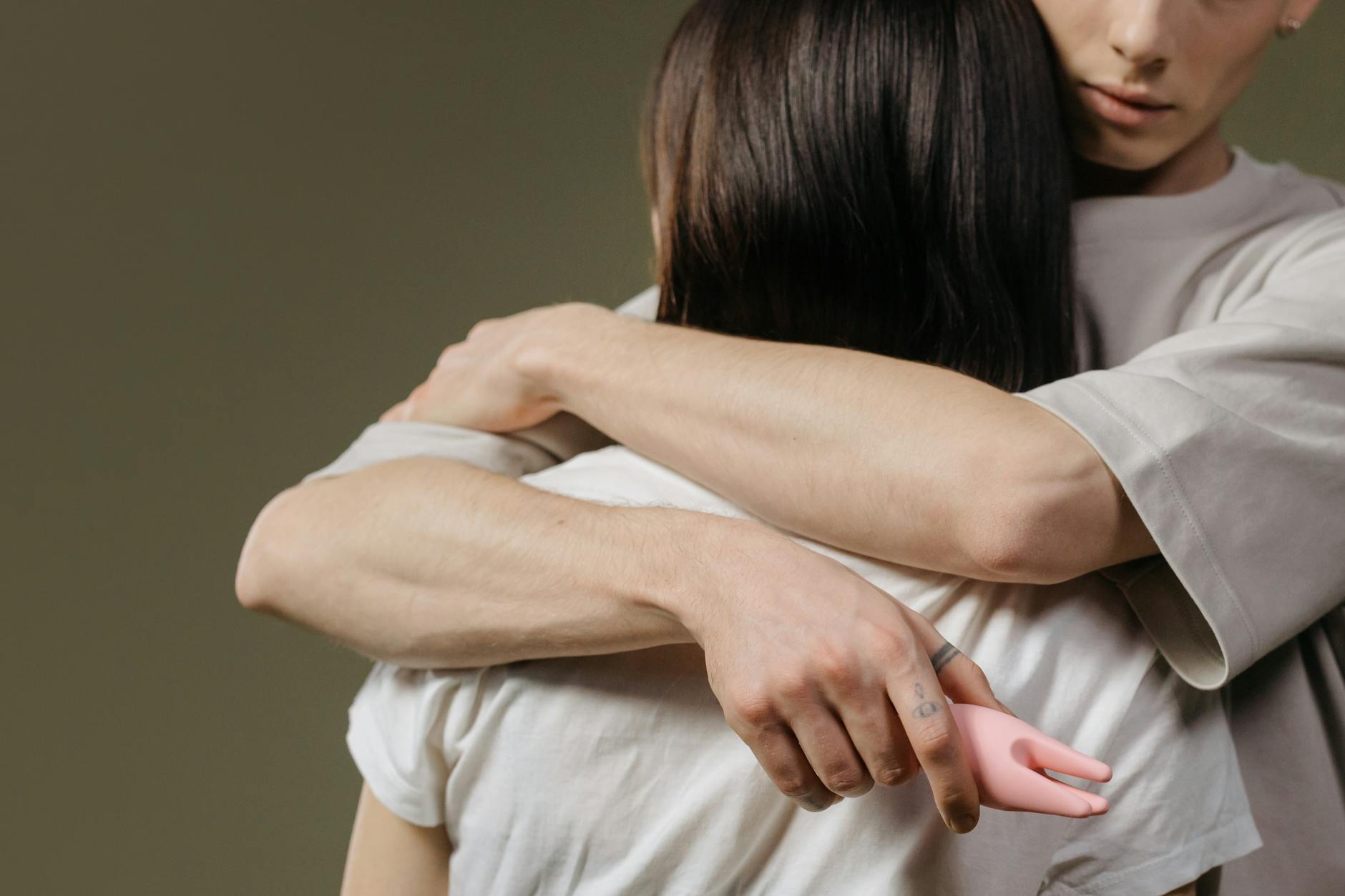 A young couple standing together indoors, holding a blue vibrator, symbolizing modern intimacy and shared pleasure.